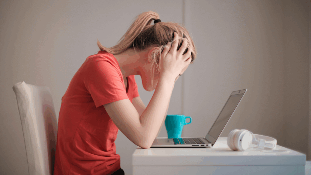 Colaboradora sobrecarregada enfrentando riscos psicossociais no trabalho